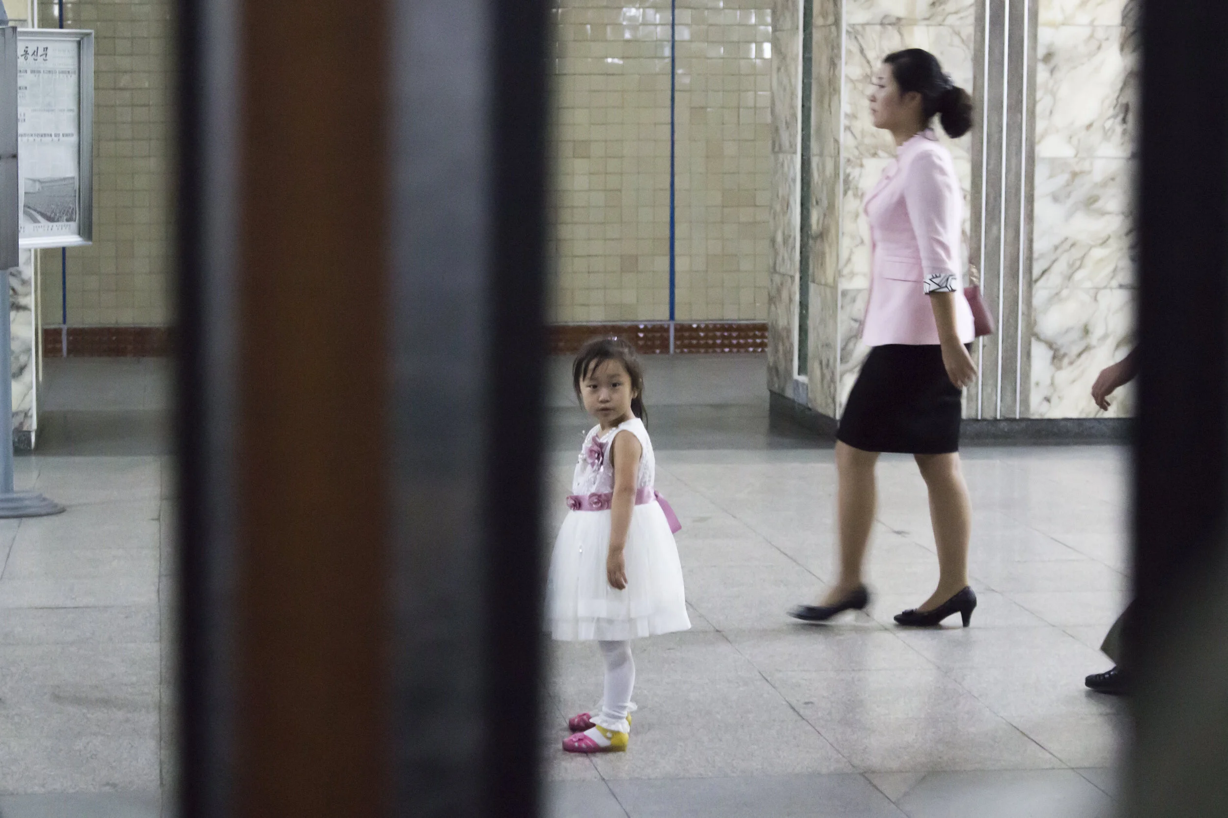 A parent and child walking through a public building